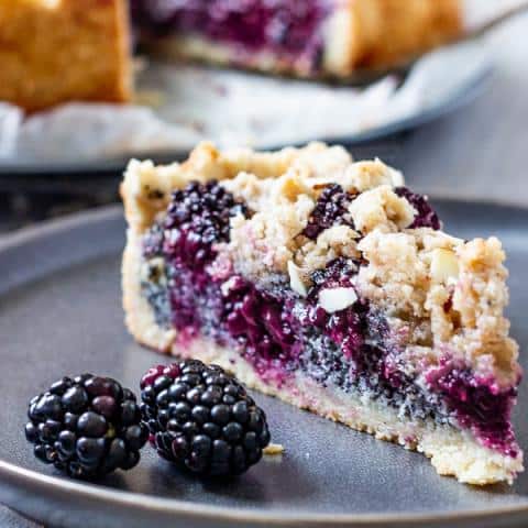Vegan crumb cake with blackberries and poppy seeds! Everyone who loves crumbles should try this healthy version of a classic crumble cake with a wholegrain shortbread made from spelt, nutmeg, an addictive poppy-seed filling, refreshingly sweet blackberries and covered with cinnamon. vegan | dairy-free | egg-free | oil-free | refined sugar free | soy free | vegetarian #vegancrumbcake #vegancake #poppyseeds #blackberries