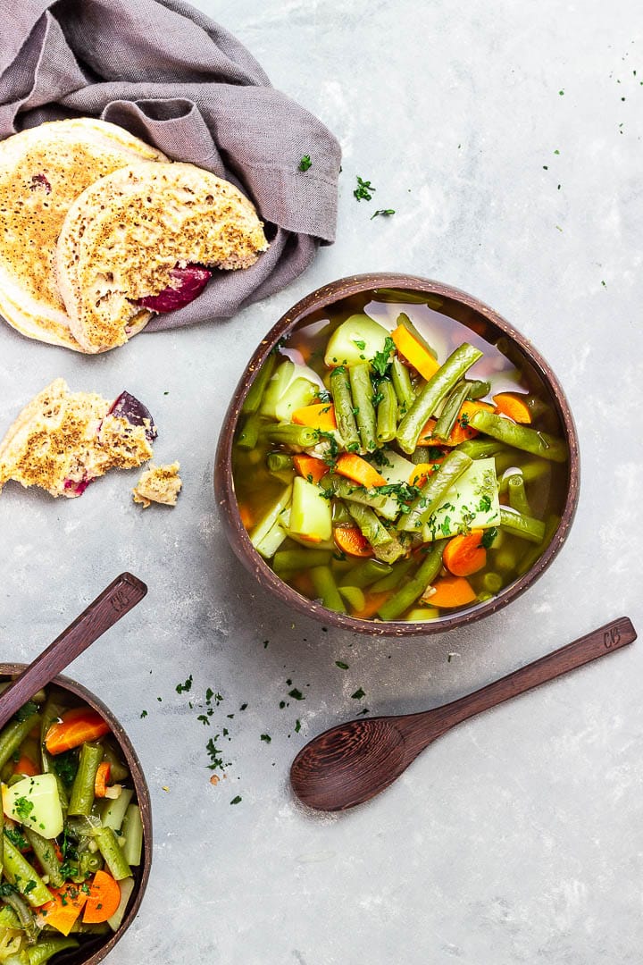 Vegane grüne Bohnensuppe mit einer kräftigen Gemüsebrühe, Kartoffeln und Karotten