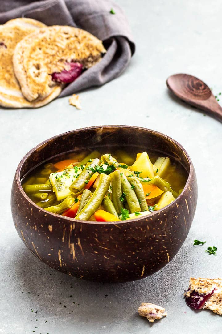 Vegane grüne Bohnensuppe mit einer kräftigen Gemüsebrühe, Kartoffeln und Karotten