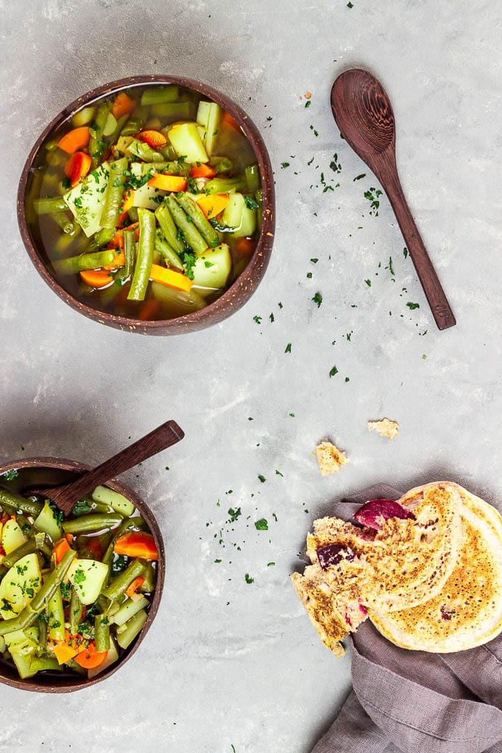 Vegane grüne Bohnensuppe mit einer kräftigen Gemüsebrühe, Kartoffeln und Karotten