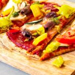 A baking stone baked vegan Pizza with a wfpb whole grain crust and an oil-free & sugar-free pizza sauce