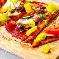 Ein auf Backstein gebackene vegane Pizza mit vollwertigem Vollkornteig und einer ölfreien und zuckerfreien Pizzasoße