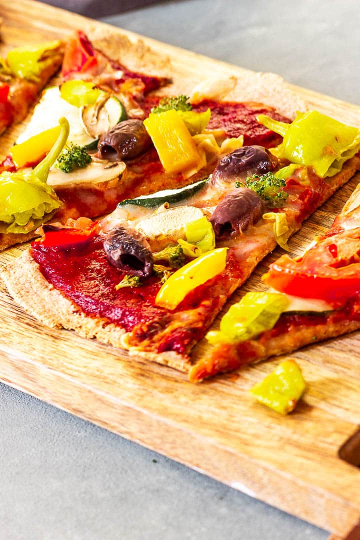 Ein auf Backstein gebackene vegane Pizza mit vollwertigem Vollkornteig und einer ölfreien und zuckerfreien Pizzasoße