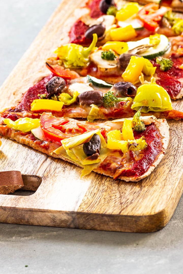 A baking stone baked vegan Pizza with a wfpb whole grain crust and an oil-free & sugar-free pizza sauce