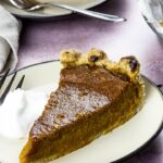 Vegan Pumpkin Pie Slice on a Plate with Whipped Coconut Cream for a Thanksgiving Dessert