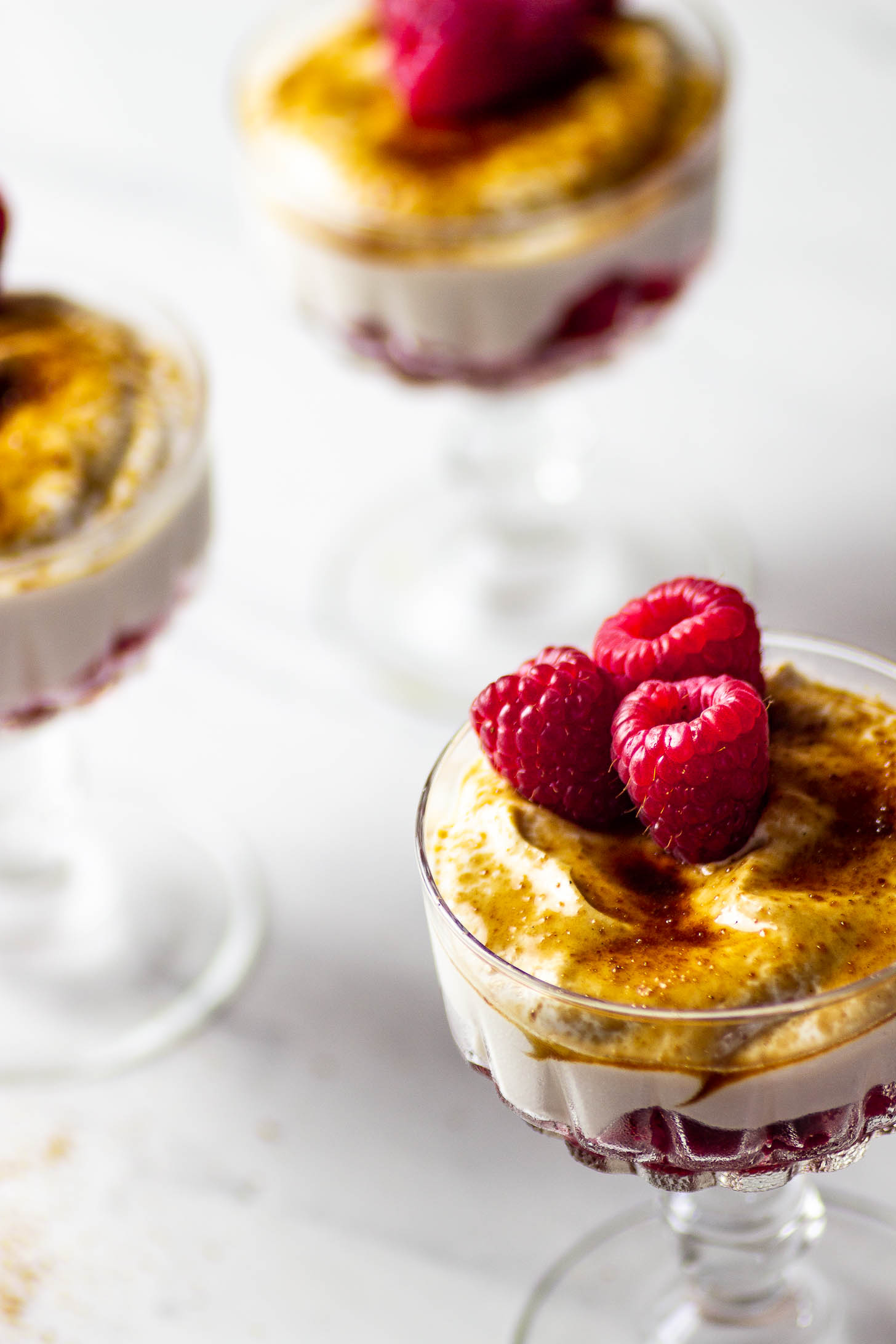 Veganer Nachtisch mit Himbeeren und einer laktosenfreien Creme, getopped mit Kokosblütenzucker oder Rohrohrzucker