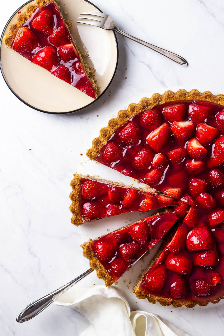 A vegan Strawberry Jello Cake with sliced pieces on a plate