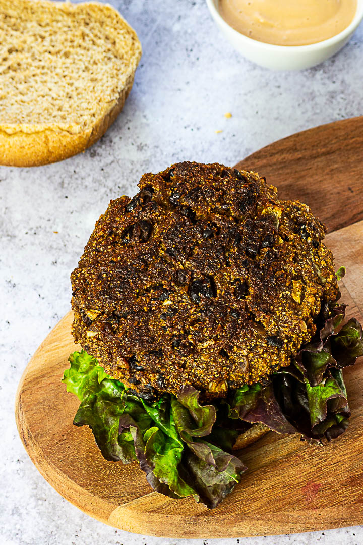 Vegan black Bean Burger with Veggies on a bun with salad