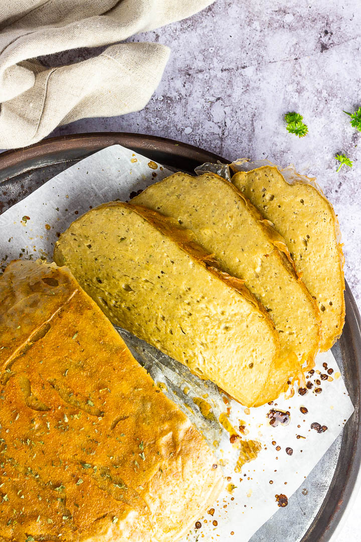 Veganer Truthahn Braten Seitan auf einem Teller zubereitet mit Kichererbsen, Tahini und einer geschmackvollen Gewürzmischung