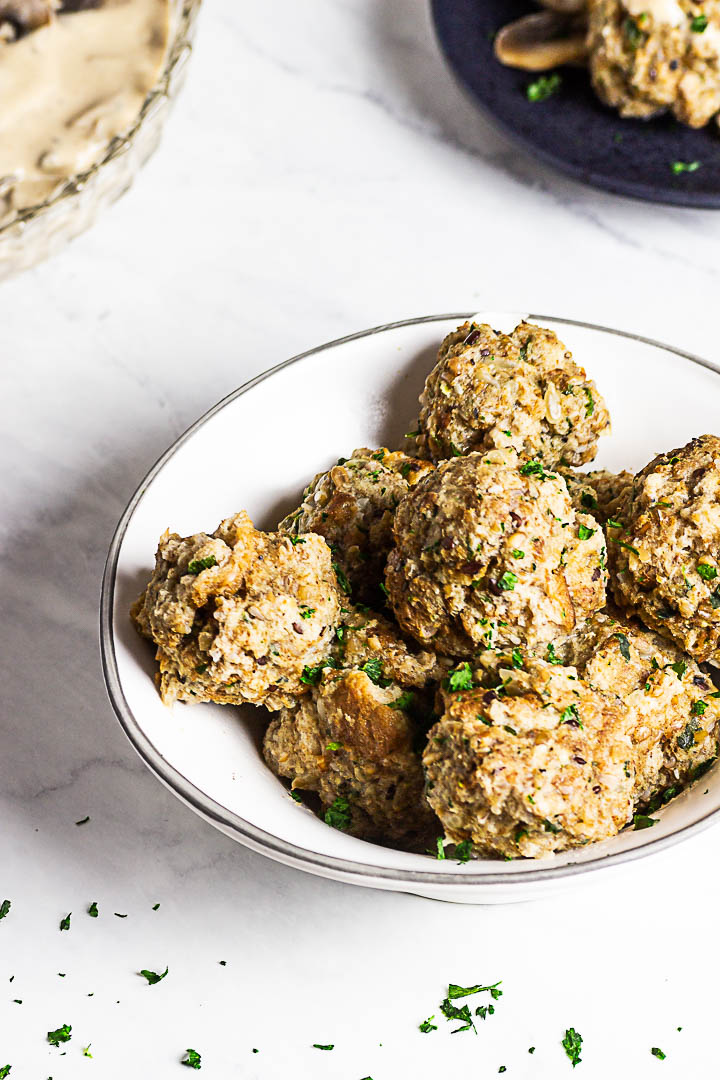 Vegan Semmelknödel are German Bread Dumplings. Presentation in a bowl with some mushroom stroganoff