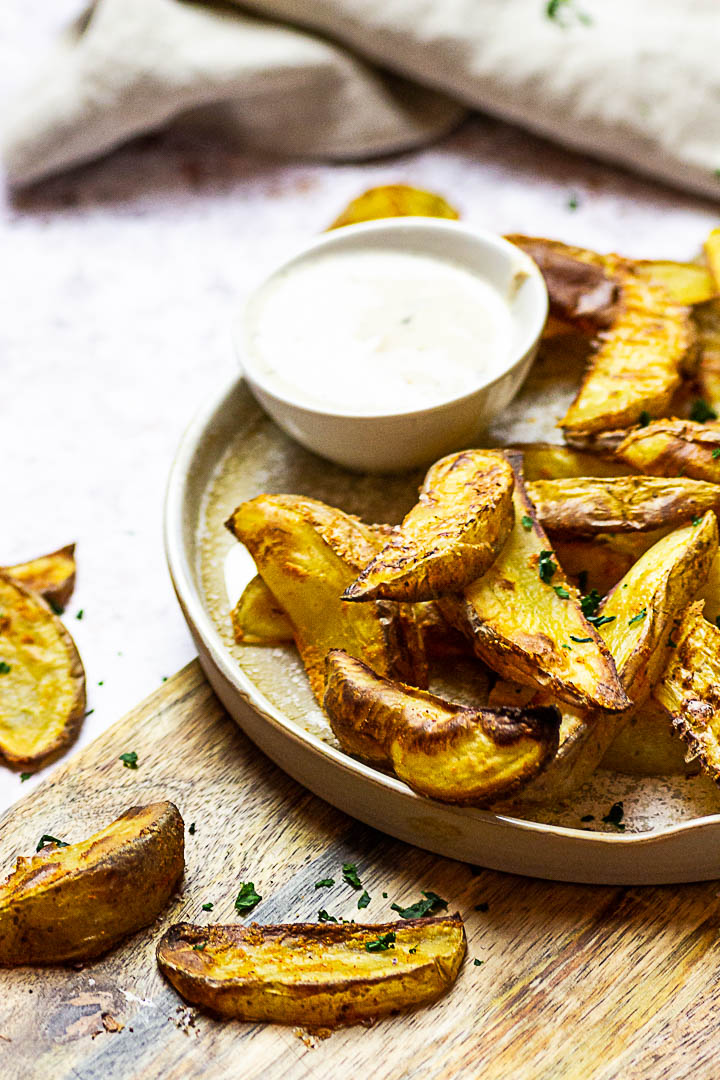 Homemade oven baked whole food plant-based potato wedges. These vegan french fries are made without oil and super quick baked.