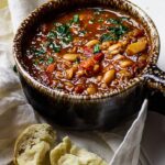 Vegane serbische weiße Bohnensuppe zubereitet aus weißen Bohnen, Grünkern, stückige Tomaten (vegetarisch)