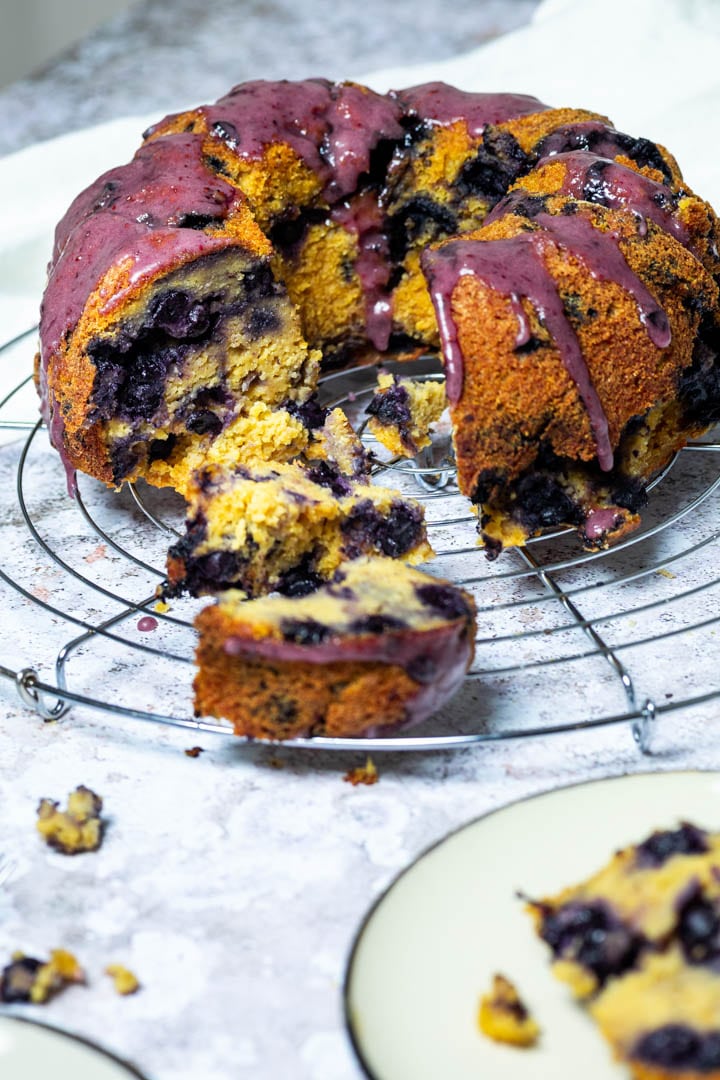 Vegan Blueberry Bundt cake on a wire rack. With a cutted piece