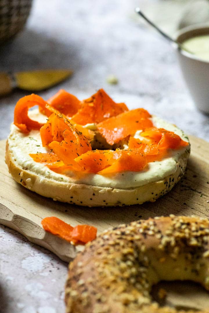 Veganer Räucherlachs aus Karotten zubereitet. Karotten Lox auf einem Bagel mit selbstgemachten ölfreien Meerrettich-Dip.