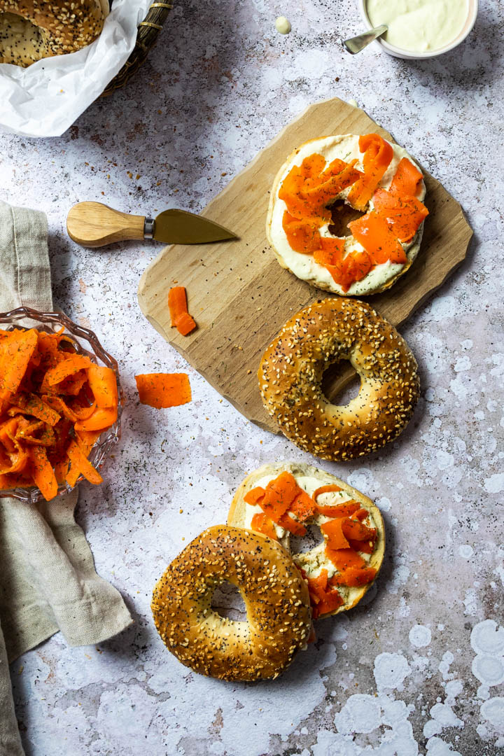 Veganer Räucherlachs aus Karotten zubereitet. Karotten Lox auf einem Bagel mit selbstgemachten ölfreien Meerrettich-Dip.