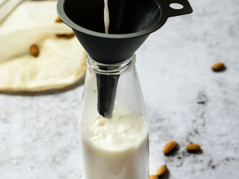 Pouring some almond milk in a jar