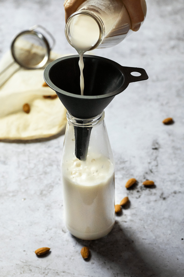 Pouring some almond milk in a jar