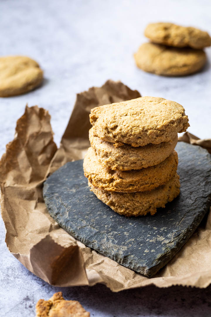 Stack of vegan buttermilk biscuits on a heart stone plate with some biscuits in the background.