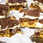 A couple pieces of the vegan custard cherry chocolate cake (Donauwelle) on a plate with some are blurred out to focus the middle cake.