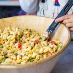 Bowl of the macaroni pasta salad. In the background my daughter holding the serving spoon.