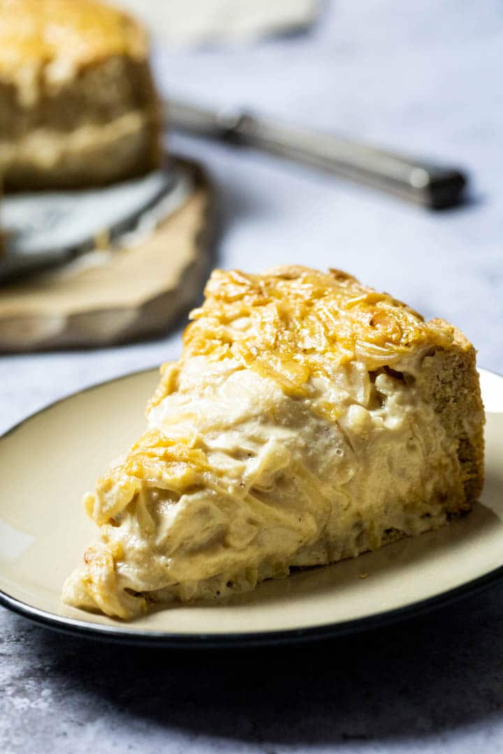 A piece of a vegan onion tart with wfpb ingredients on a plate