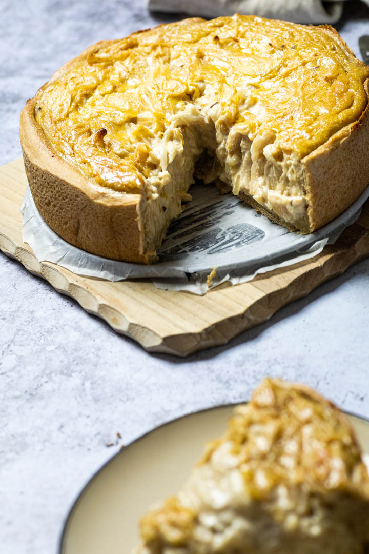 Vegan Onion Tart on a board with a blurred piece in front