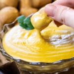 Pretzel Bite dipping in some vegan nacho cheese dip