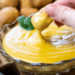 Nahaufnahme des Bier Käse Dips in den ein Stück Brezel reingetunkt wird