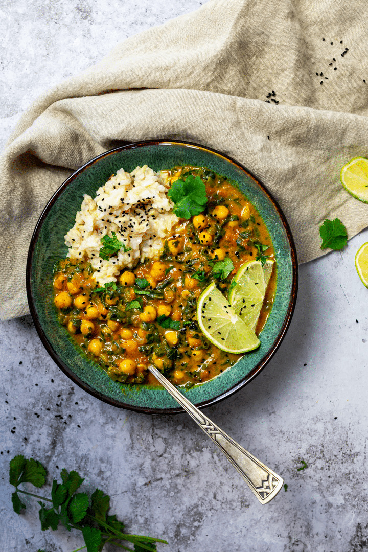 Vogelansicht auf eine Schüssel mit Kichererbsen Curry und Naturreis. 