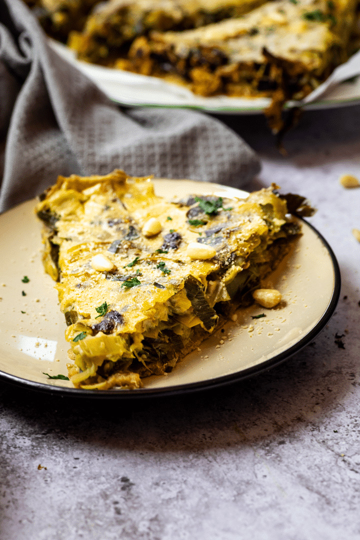 Slice of a vegan leek quiche on a plate