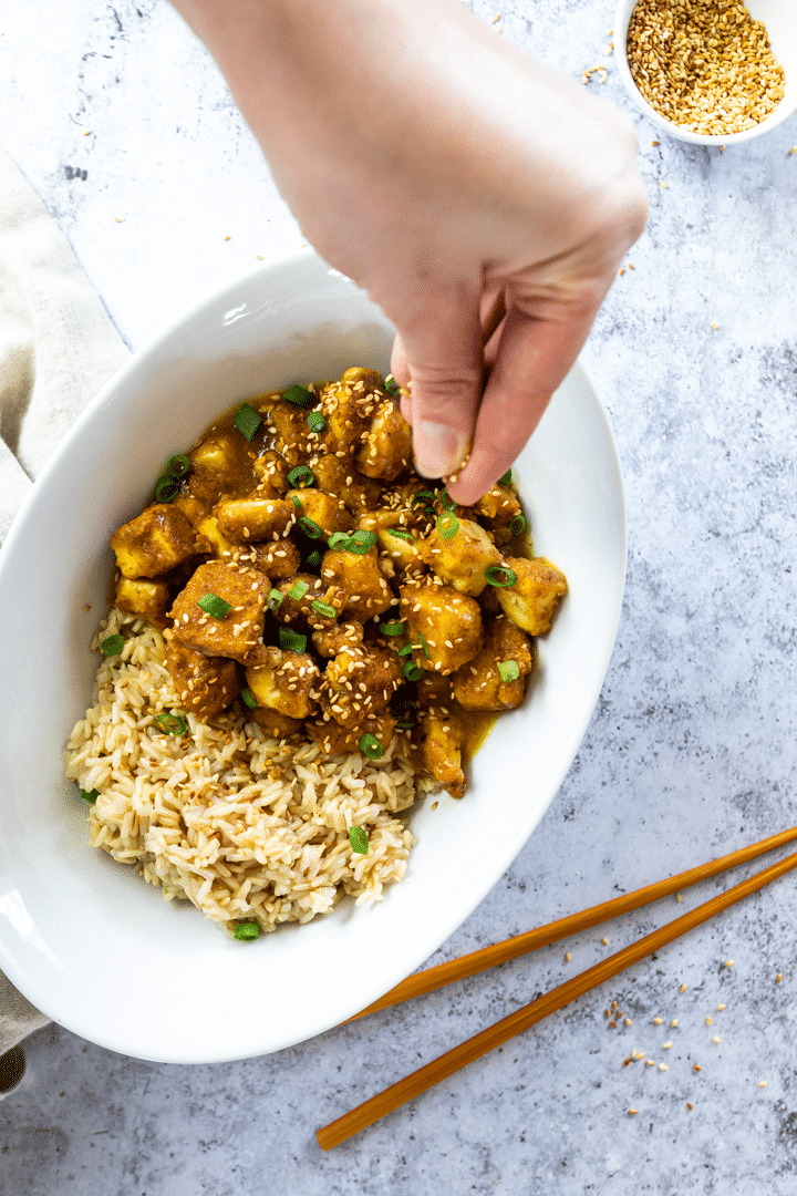 Vegan Orange Tofu in a bowl and sprinkle some sesame seeds 