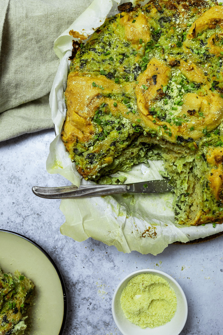 A pan with artichoke spinach pinwheels with one missing roll.