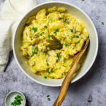 Vogelansicht des veganen cremigen Kartoffelsalats mit einem Servierlöffel