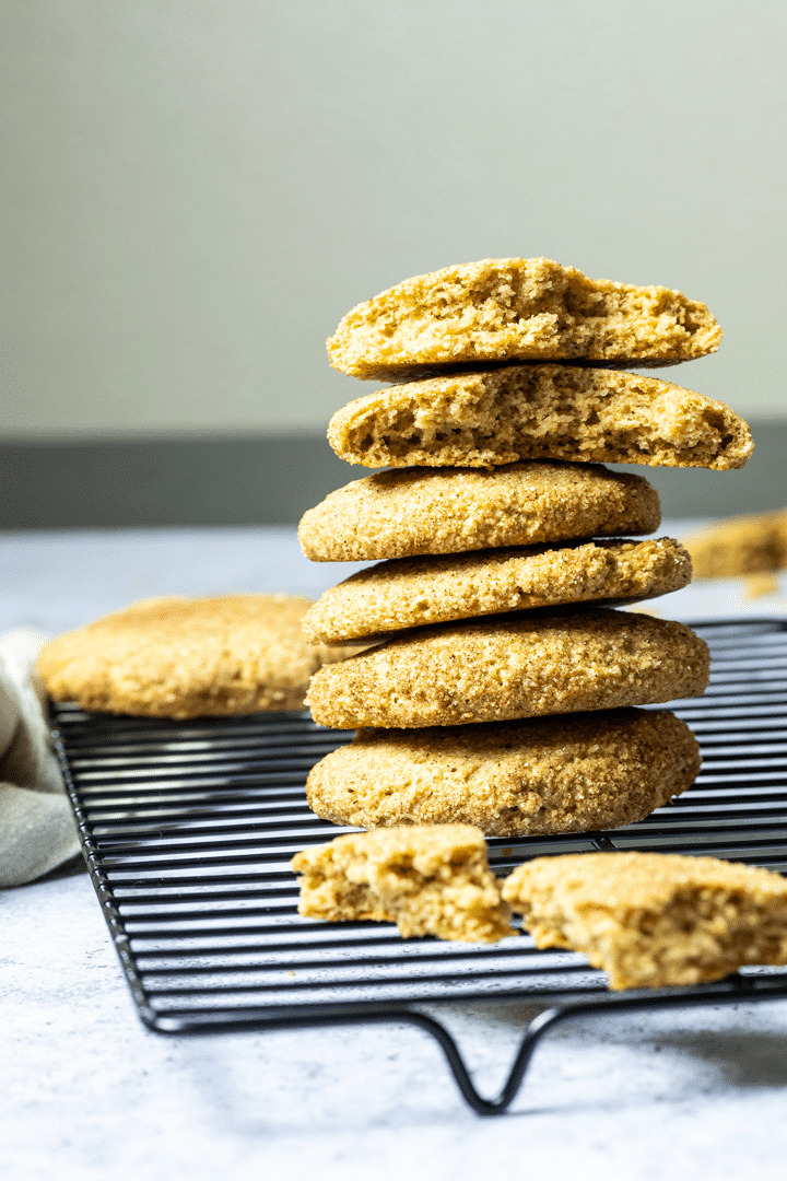 Stack of vegan wfpb snickerdoodles with some snickerdoodle pieces in front