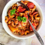 Flatlay of vegan american goulash in a bowl with a spoon