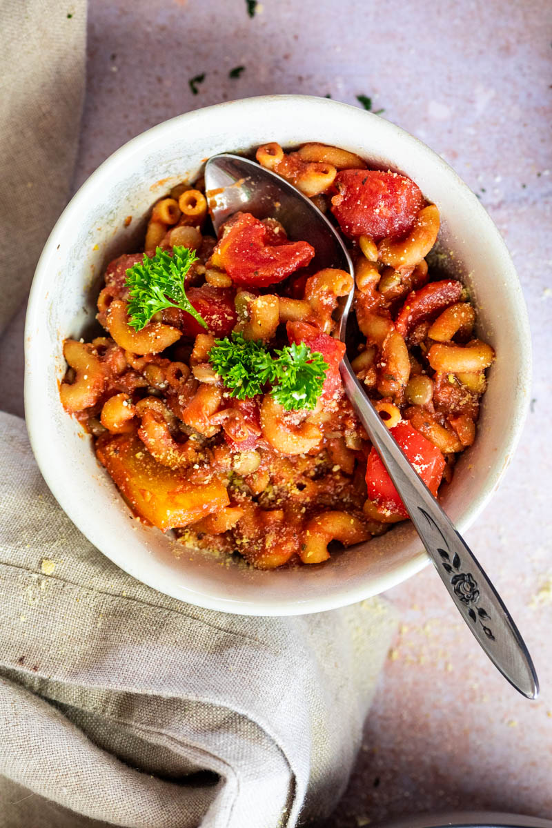 Flatlay of vegan american goulash in a bowl with a spoon