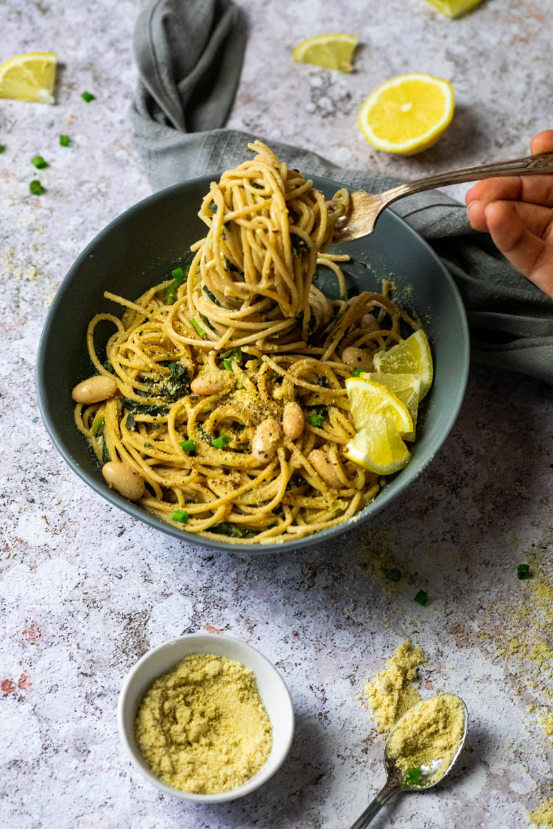 Vegane Zitronennudeln in einer Schüssel mit einer Gabel voller Spaghetti