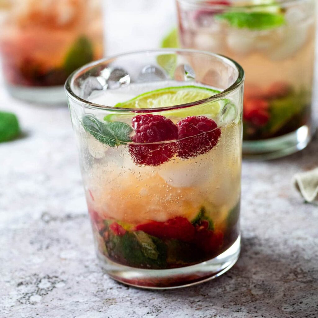 close up of a glass full with refined sugar-free raspberry mojito