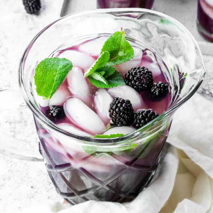 Close up of a pitcher full with blackberry iced tea.