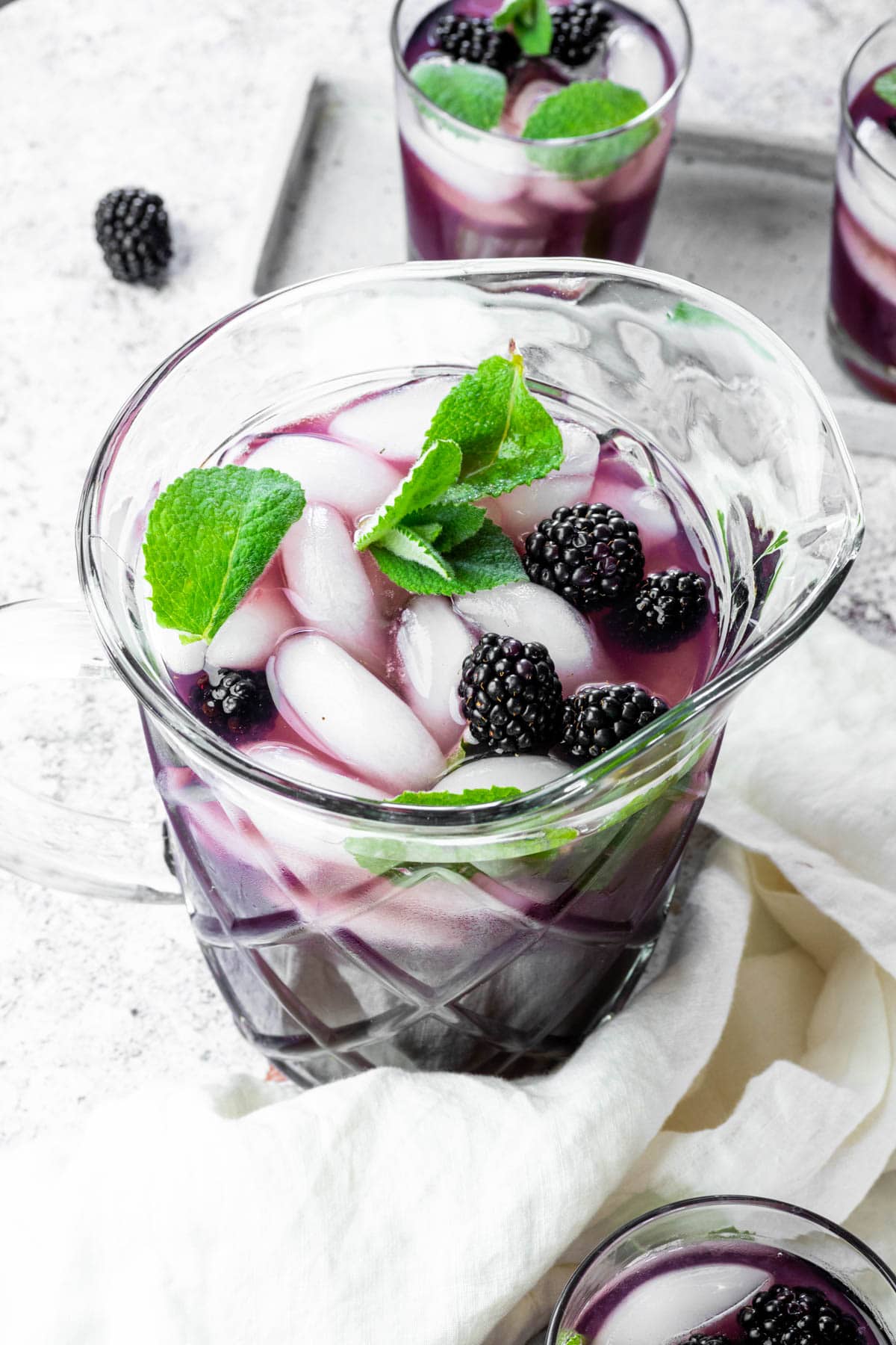 Close up of a pitcher full with blackberry iced tea.