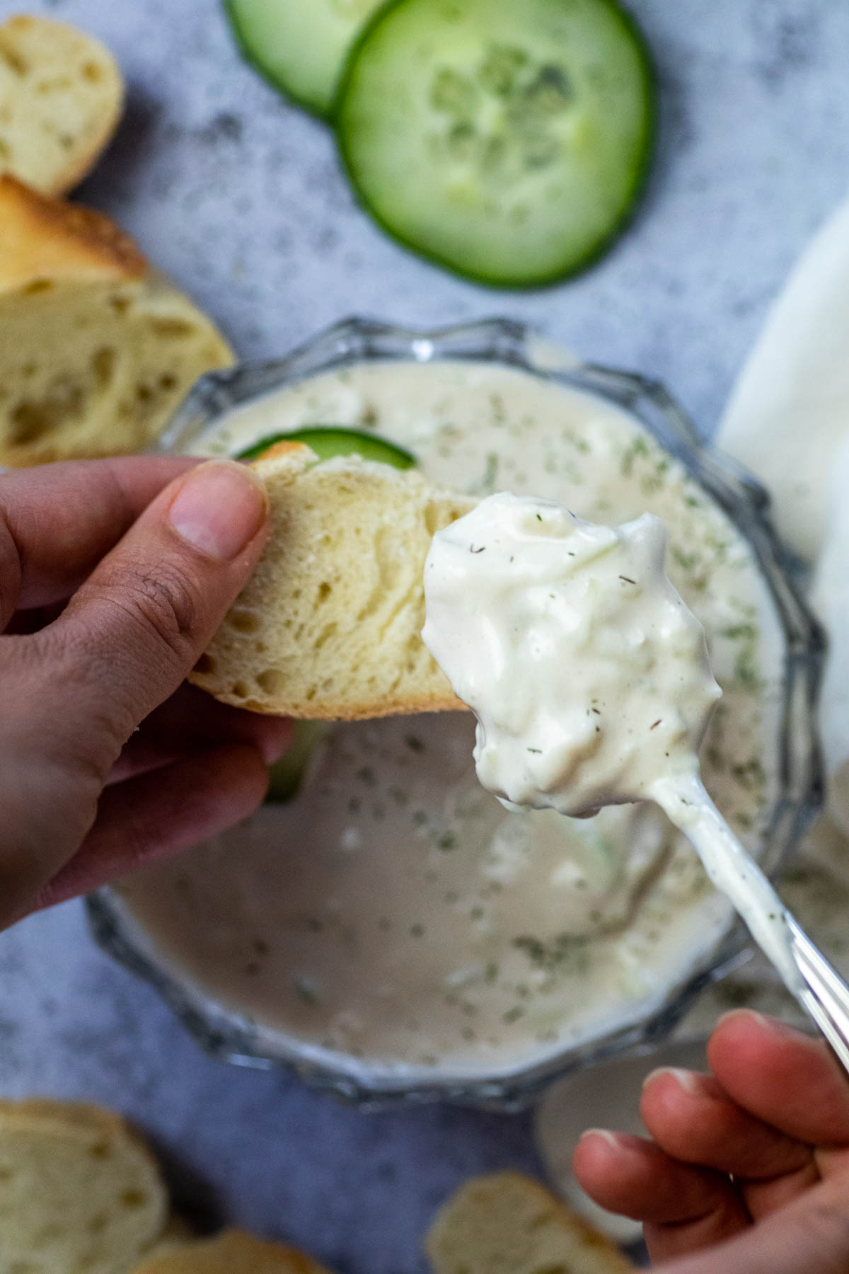 Putting some vegan Tzatziki on a slice of baguette