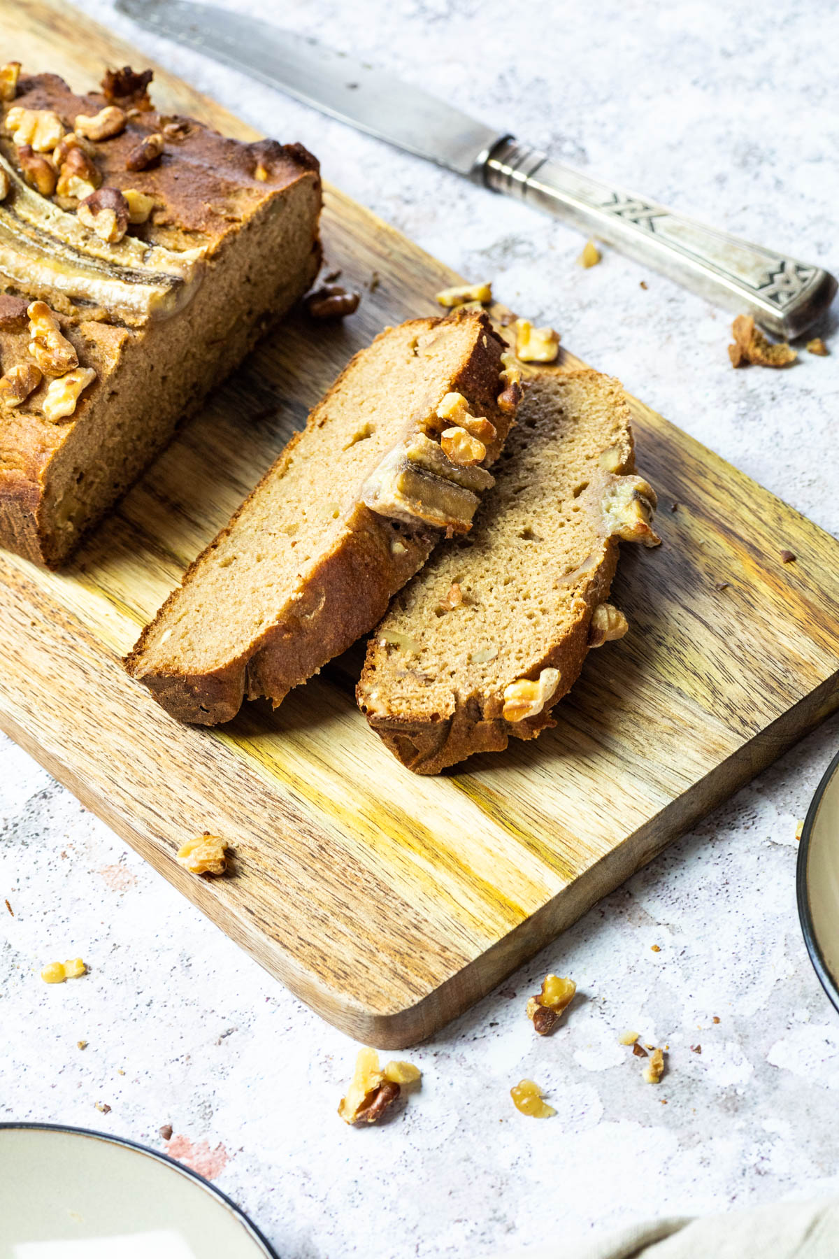 Geschnittenes veganes wfpb-Bananenbrot auf einem Schneidebrett.