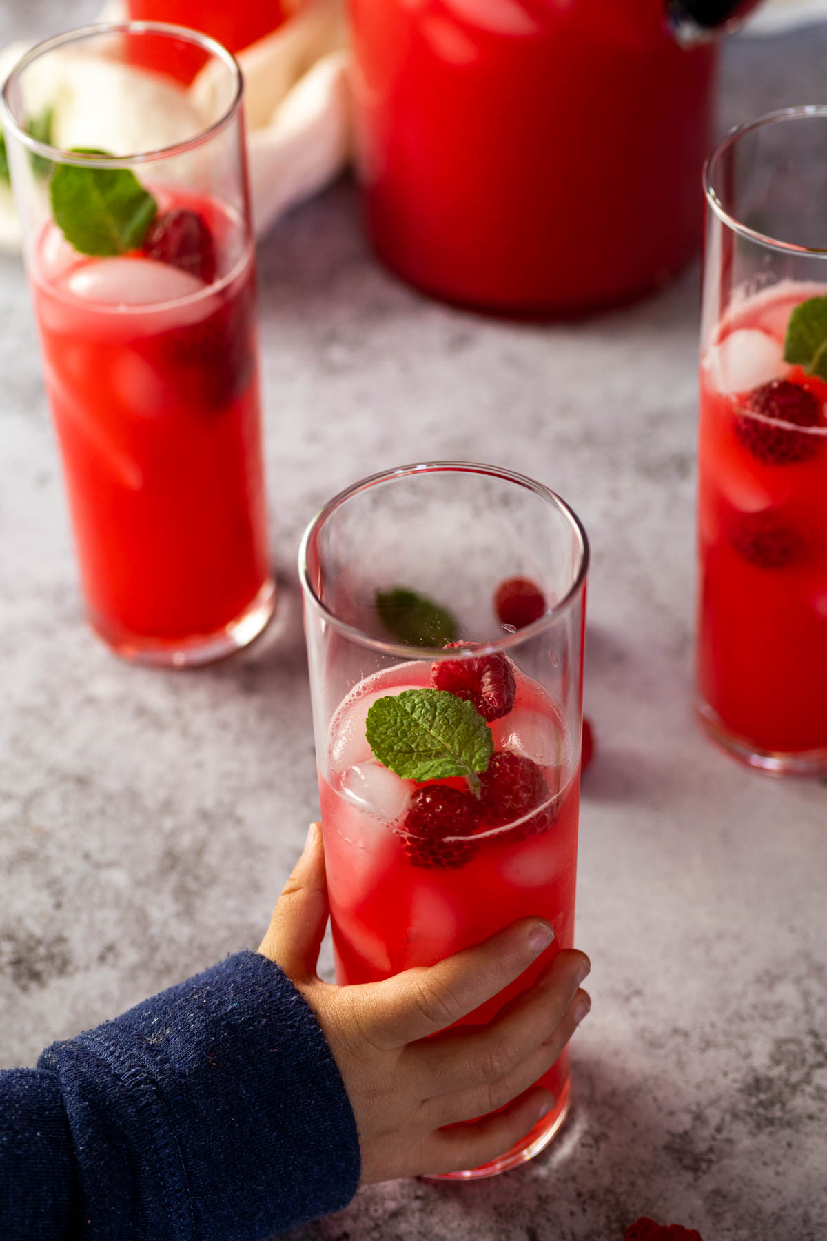 One glass of raspberry limeade in focus