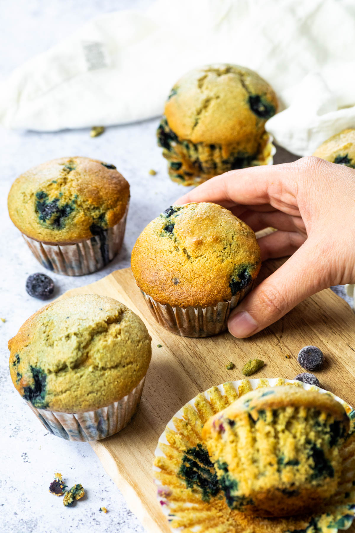 Holding one vegan blueberry muffin