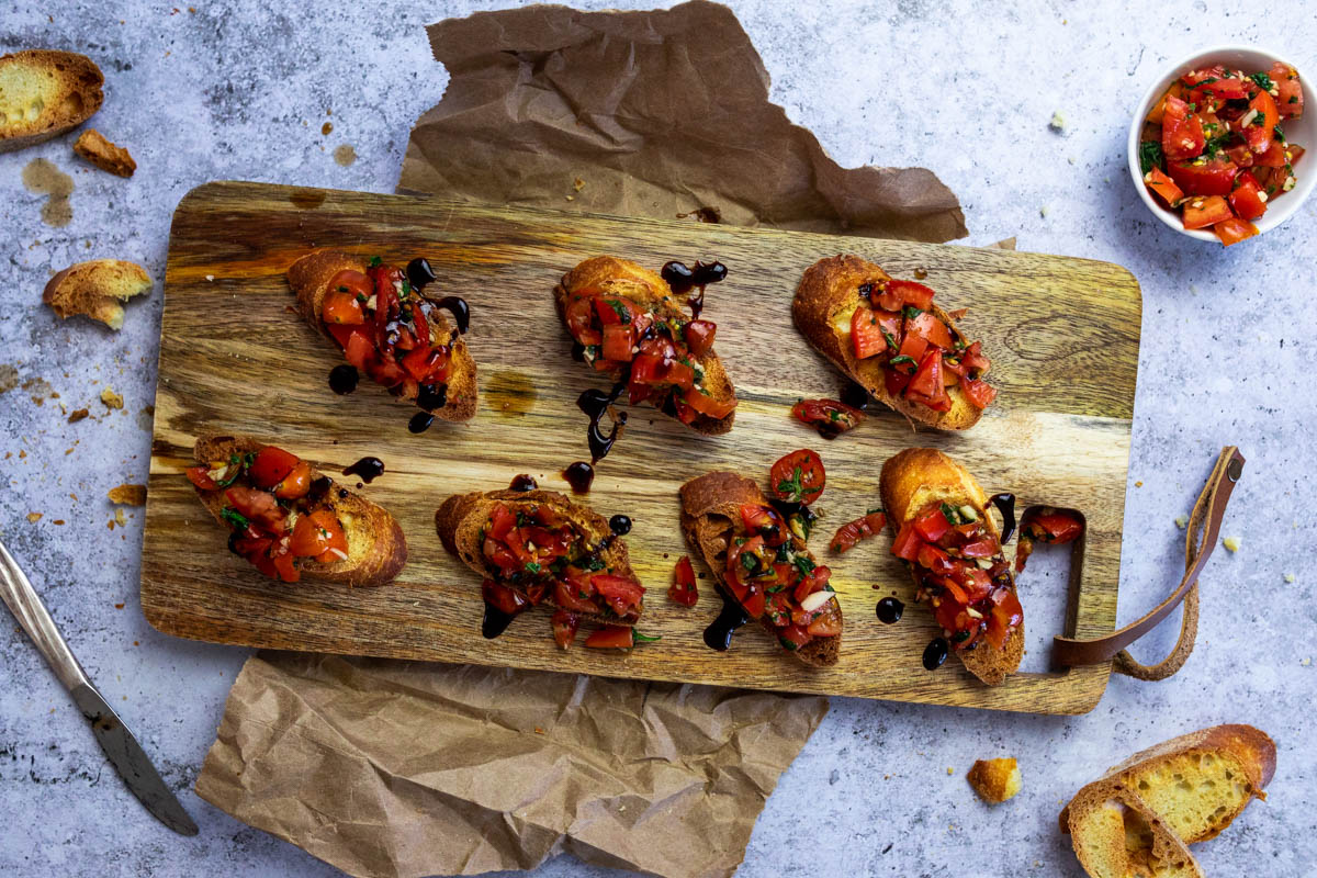 Vogelansicht eines Brettes mit Bruschetta Crostini.