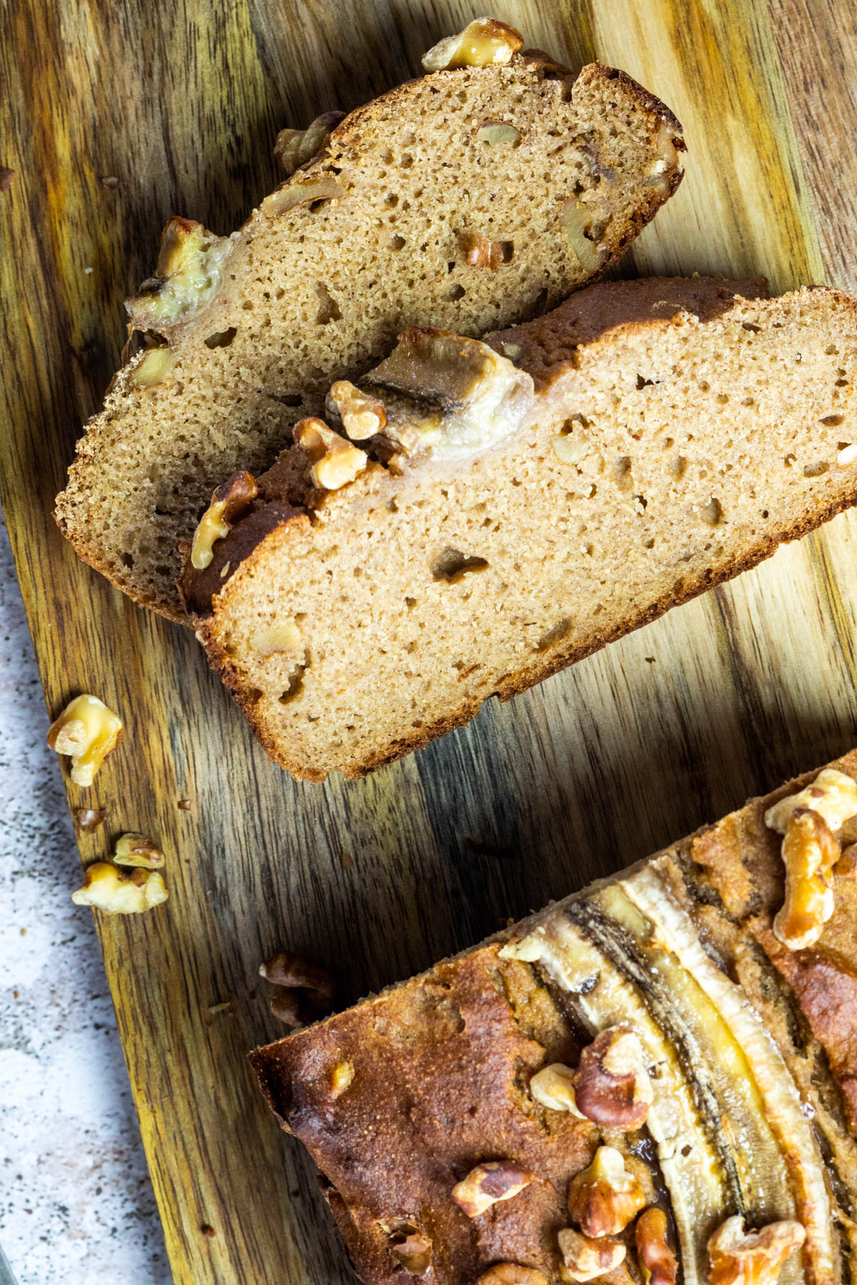 2 vegane wfpb Bananenbrotscheiben auf einem Holzbrett