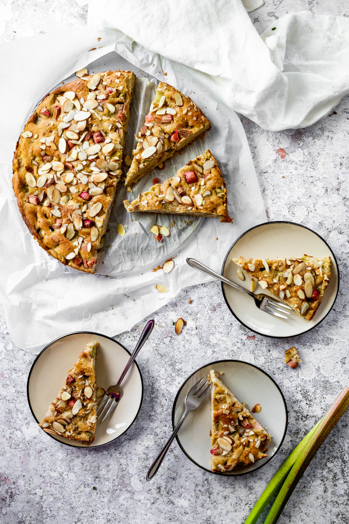 Plant Based Rhubarb Cake with 3 slices on plates.