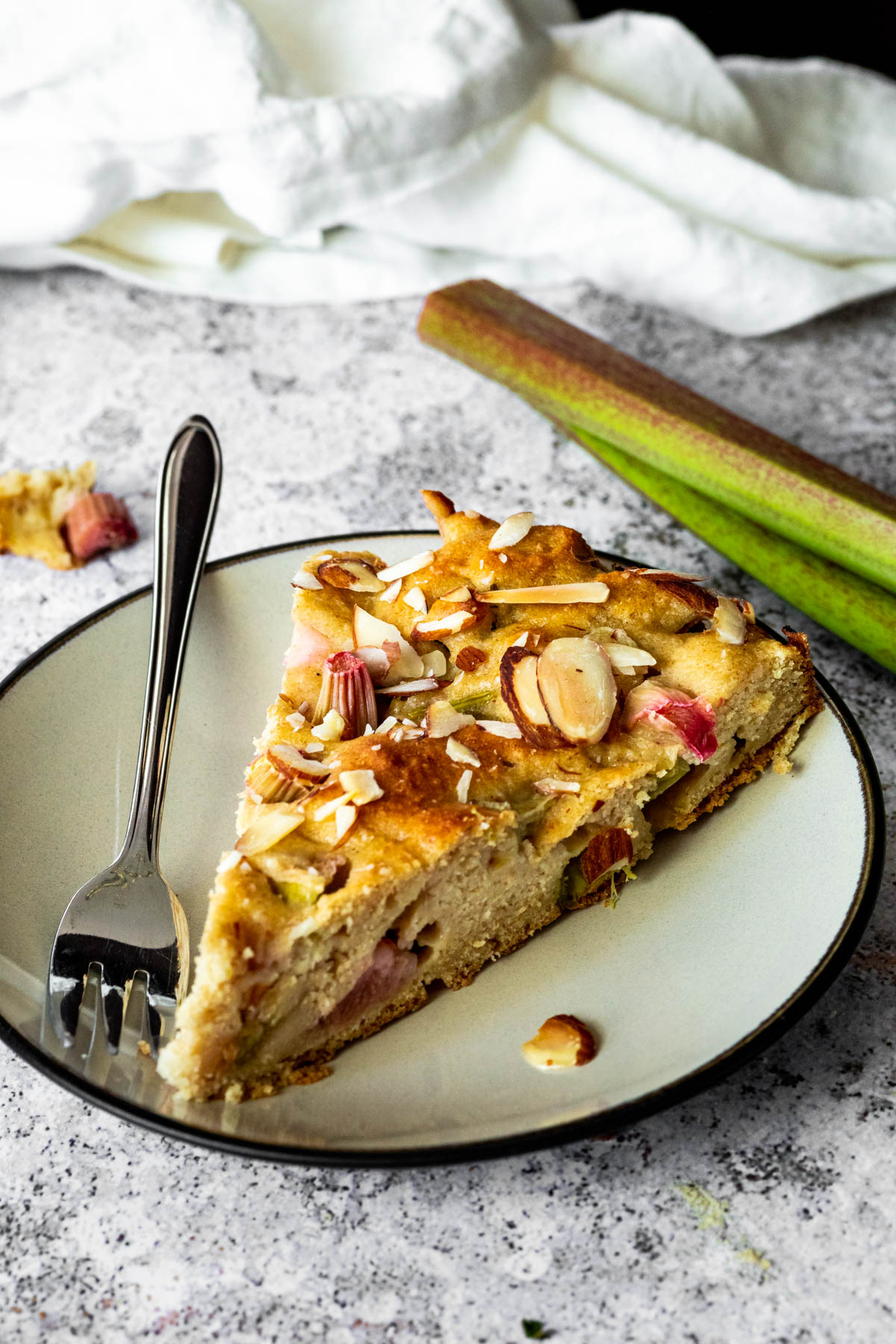 ein veganes Rhabarberkuchenstück auf einem Teller