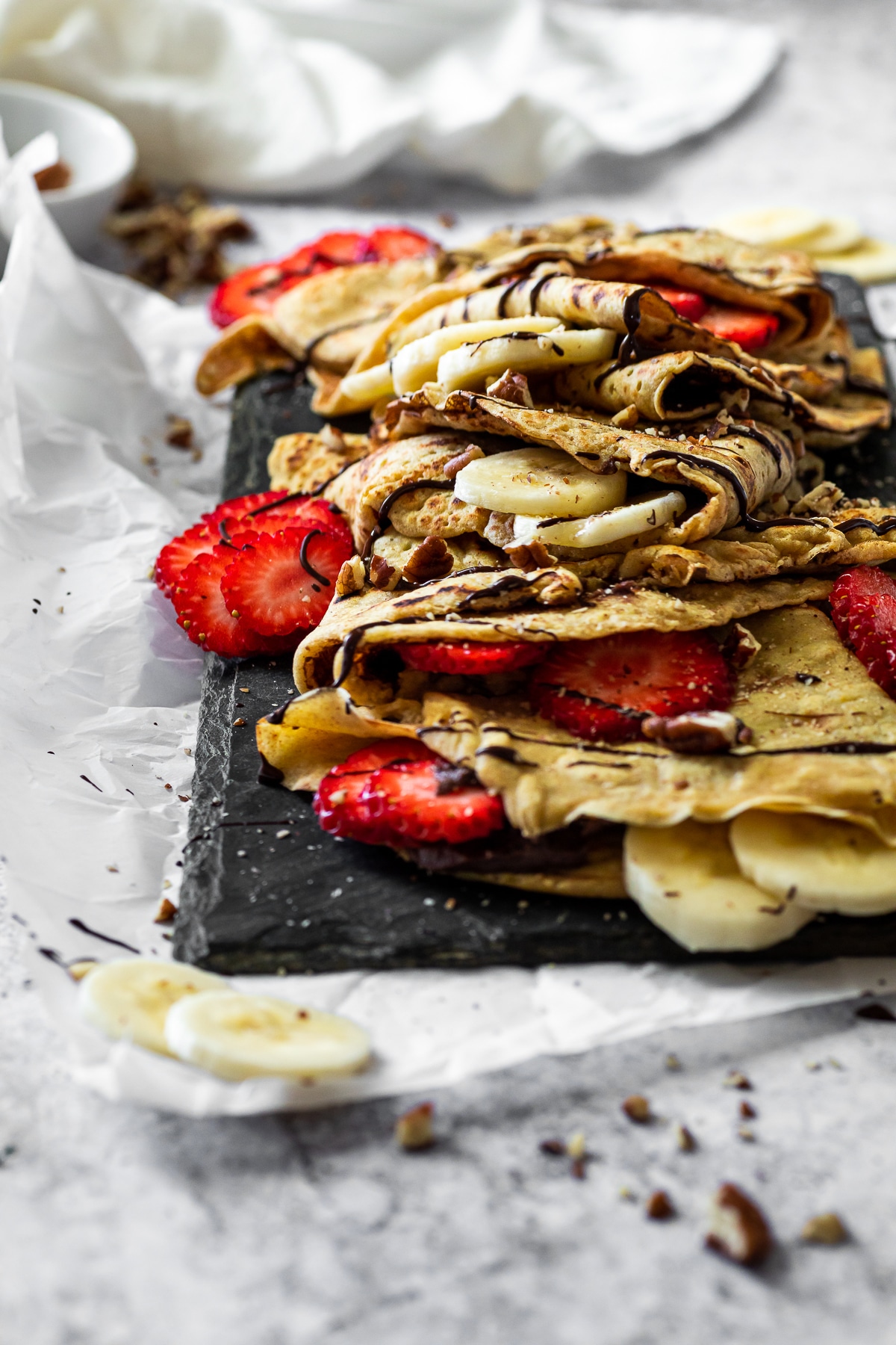 Gerade Ansticht auf die gefüllten Crepes mit Schokoladenhummus, Banane und Erdbeeren