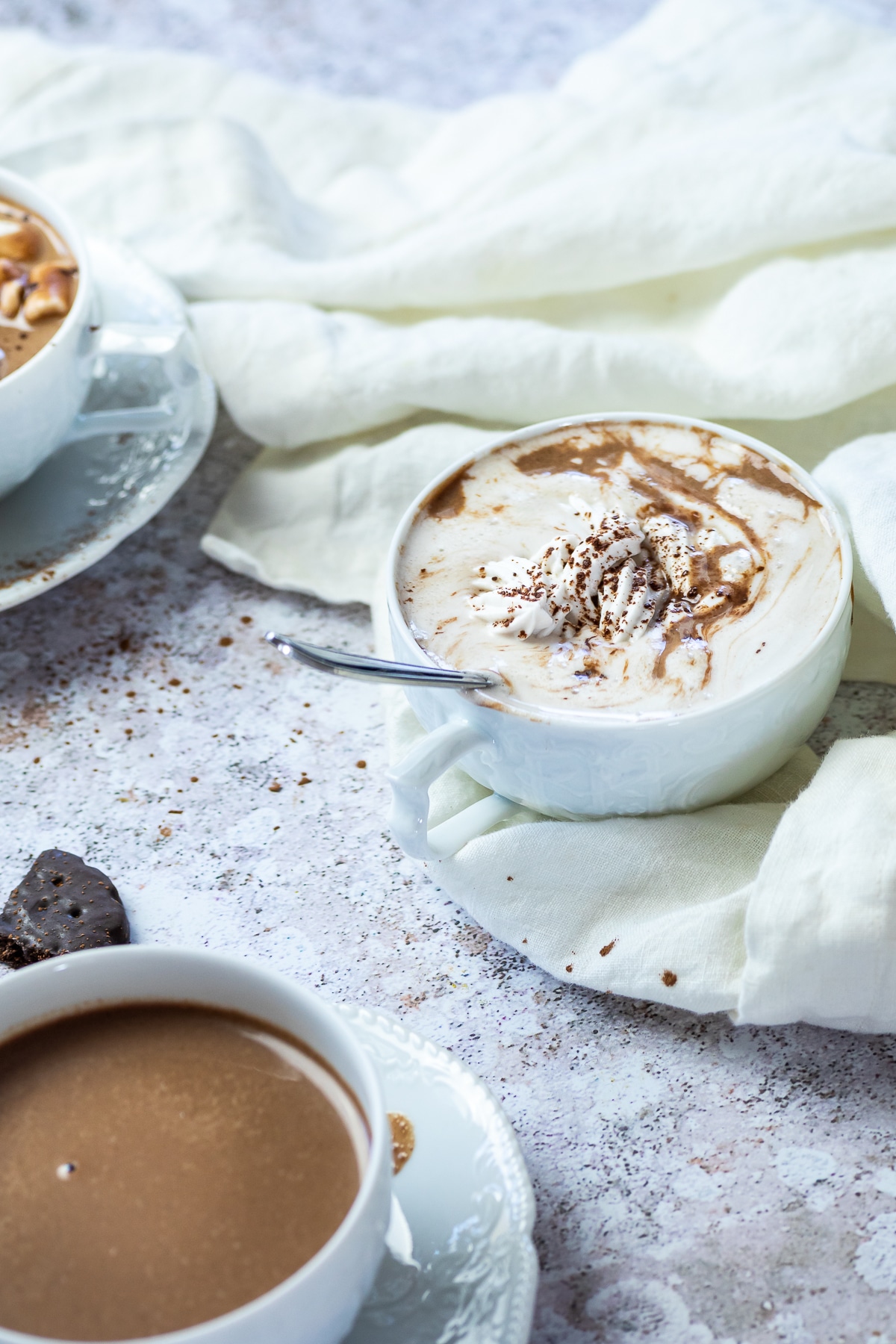 A cup with vegan hot chocolate (sugar free) and topped with homemade coconut whipped cream.